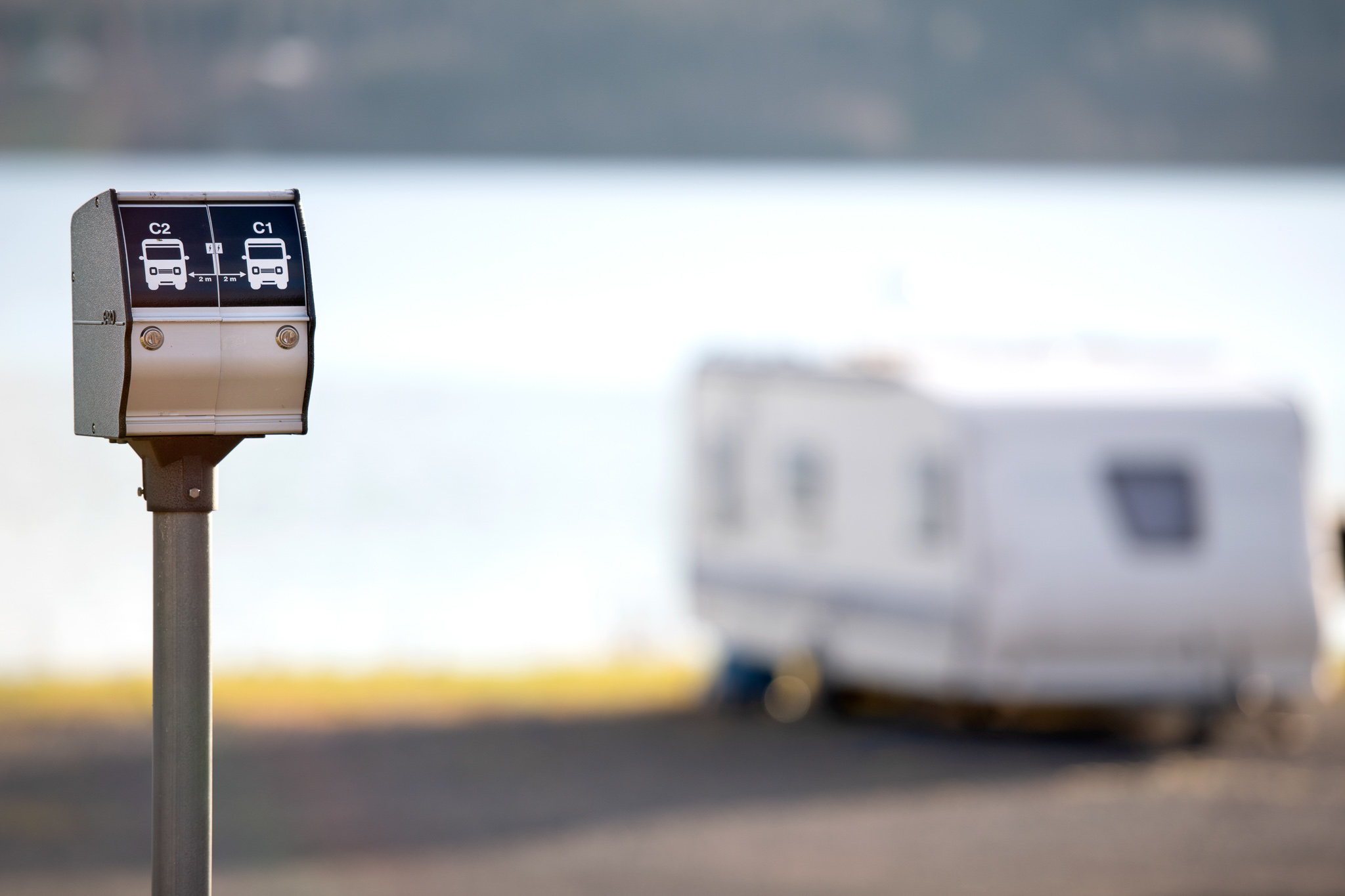 Elanslutning vid tomt, med husvagn i bakgrunden.