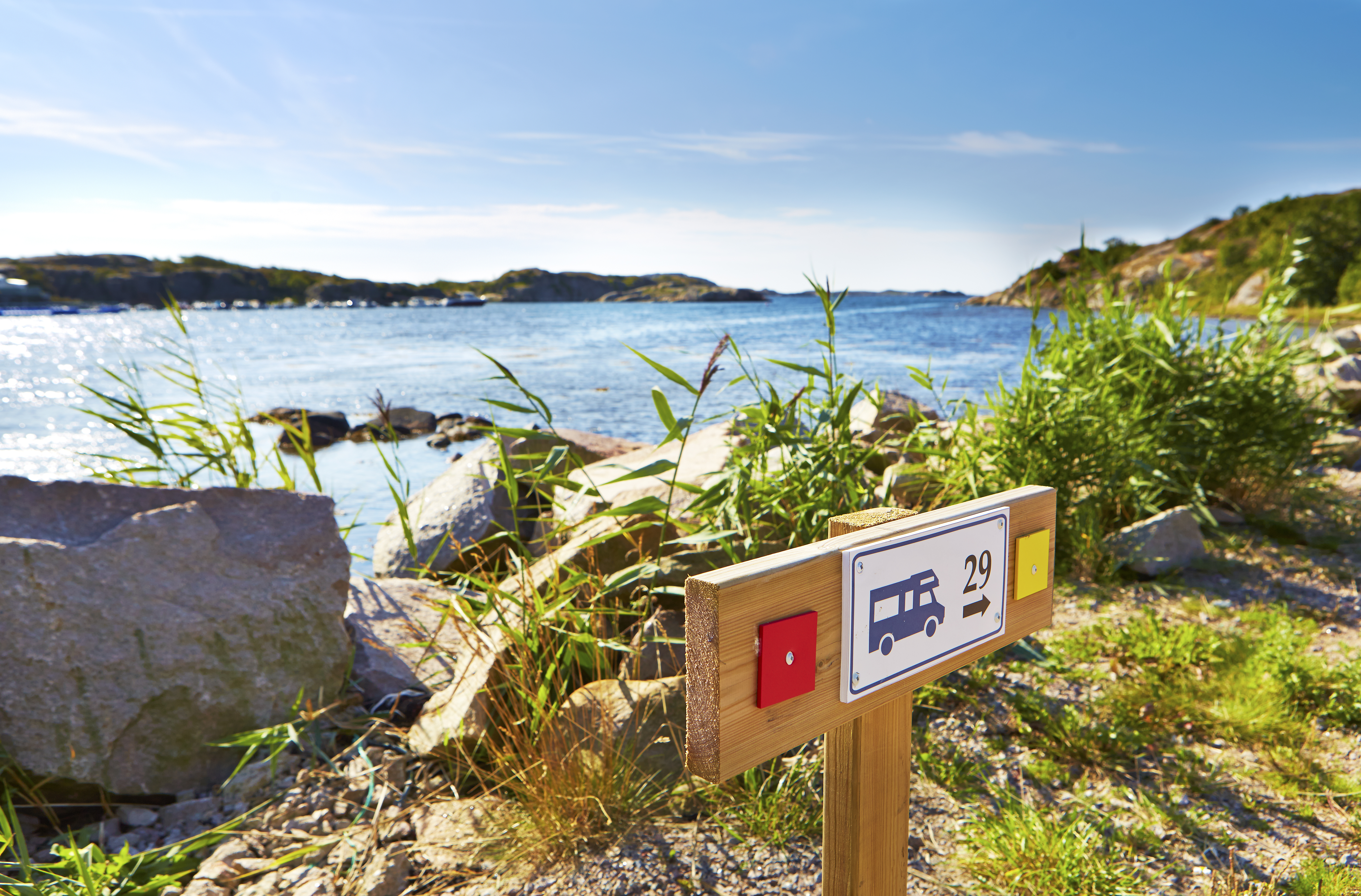 Kustlandskap med en skylt som pekar mot en husbilsplats.